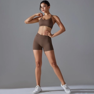 Detail of cross-back seamless yoga bra and high-waisted shorts in brown sporty fabric