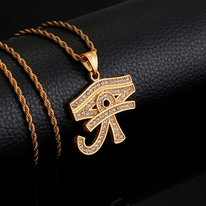 Detailed close-up of golden Horus eye pendant with sparkling crystals on rope chain
