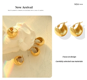 Detailed view of C-shaped chunky gold earrings featuring a polished finish and inner ribbing