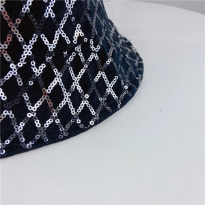 Macro shot of silver sequins in diamond grid pattern on black fabric sun hat