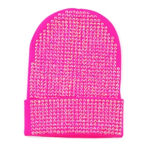 Dettaglio del berretto in maglia rosa acceso con strass brillanti e trama