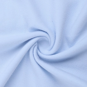 Gros plan sur un tissu en maille bleu clair avec un pli en spirale et une texture douce