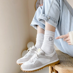 Chic color-block sneakers in white and grey with textured rubber soles on model