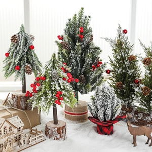 Mini snowy Christmas tree with red berries and pine cones on a rustic wooden base