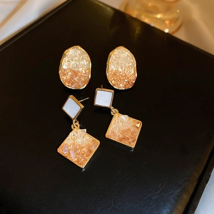 Close-up of vintage geometric oval and square earrings with crystal gravel texture