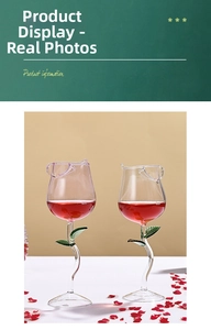 Detail of two creative rose-shaped wine glasses with green leaf stems and red wine