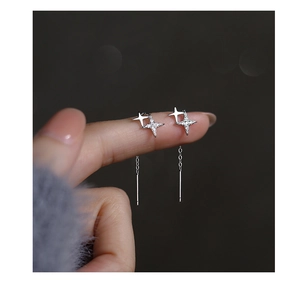 Detailed close-up of sterling silver four-pointed star earrings with zircon inlay