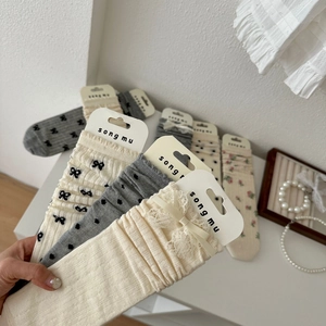 Dettaglio di calze stile giapponese con fiocchi di pizzo e ricami a pois eleganti