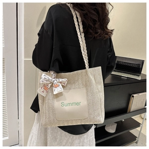 Détail du sac cabas en paille tressée avec motif en V et foulard décoratif en soie