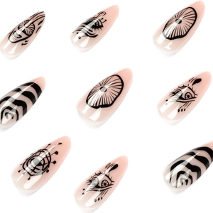 Hand-painted long stiletto press-on nails with abstract black eyes and wavy line patterns