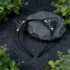 Detailed shot of bohemian black cat ear headband with dark quartz crystals on stone