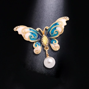 Elegant butterfly pin brooch with blue enamel wings, yellow gemstone, and pearl drop