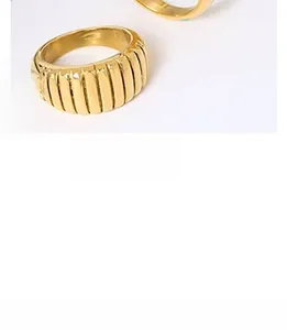 Macro detail of a gold croissant ring featuring vertical striped texture and pleated design