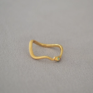 Detailed view of a gold snake ring featuring scaly texture and colorful gemstone accents