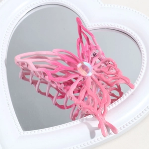 Detailed view of pink gradient butterfly hair claw with jewel on heart mirror