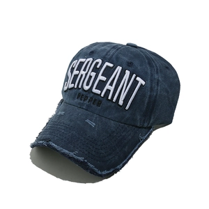 Detail of 3D embroidery and distressed brim on navy washed cotton baseball cap