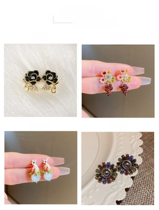 Detailed views of tulip pearl earrings with black enamel rose and rabbit charms