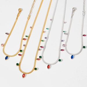 Flat lay of gold and silver snake bone necklaces with colorful zircon oval fringe pendants