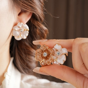 Détails macro de boucles d'oreilles fleurs vintage avec perles et cristaux blanc et brun