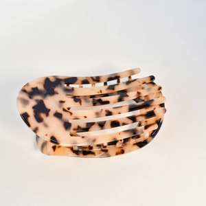 Close-up of tortoise shell pattern acetate hair claw clip with glossy leopard print finish