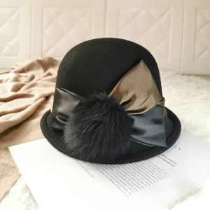 Elegant black wool felt cloche hat with a large satin bow and fluffy pompom detail