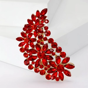 Detailed macro shot of vintage gold floral brooch set with sparkling red crystals