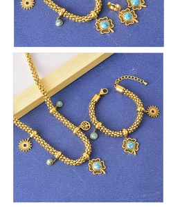 Detail of golden jewelry set with turquoise clover charms on multi-strand bead chains