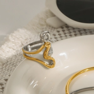 Primo piano di un anello a onda bicolore su un piatto di ceramica con finitura lucida