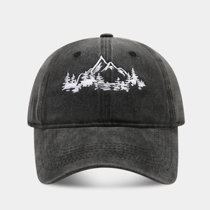 Close-up of mountain forest embroidery on washed charcoal cotton baseball cap fabric