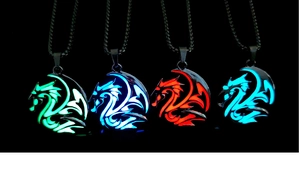 Luminous dragon totem necklaces glowing in four vibrant colors on a dark backdrop