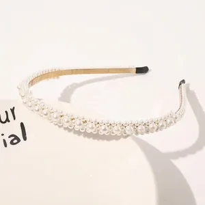 Detailed view of elegant pearl headband with gold metal base and black comfort tips