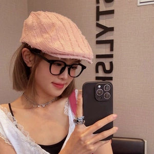 Détail de la casquette gavroche rose avec bords effilochés et texture denim délavé
