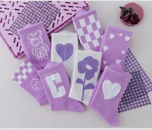 Mise à plat de chaussettes en coton violet et blanc avec motifs d'ours et de cœurs