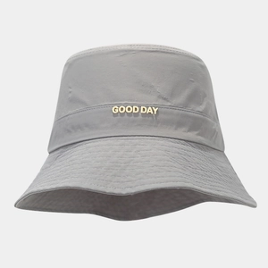 Close-up of grey waterproof bucket hat with gold GOOD DAY metal letter logo detail