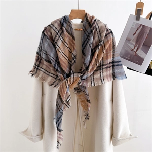 Classic plaid cashmere-feel scarf in brown and blue with tassel fringe on beige coat
