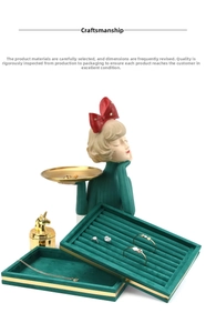 Close-up of emerald velvet jewelry tray with golden trim and decorative ornaments
