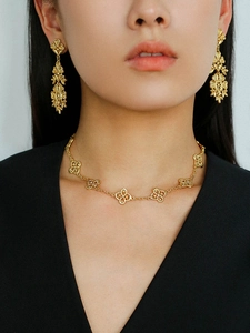 Close-up of vintage hollow flower tassel earrings and necklace set on a fashion model