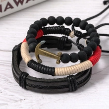 Detail of multi-layered leather bracelets set featuring bronze anchor and black beads