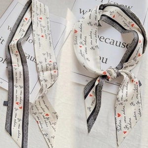 Detail of silk scarf with Je vous adore text and heart pattern as neck or bag decor