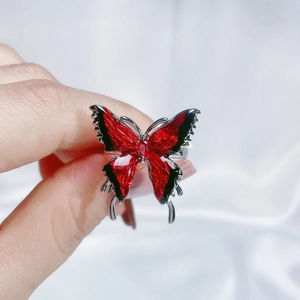 Detailed view of a red and black enamel butterfly ring with ruby-like centerpiece stone