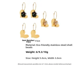 Détail de boucles d'oreilles cœur en plaqué or 18k avec fleurs résine et perles