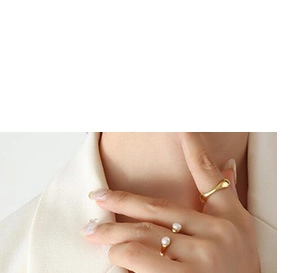 Close-up of a gold adjustable ring featuring a freshwater pearl and a teardrop design