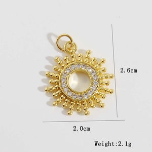 Détail du pendentif soleil doré avec zircon central et dimensions de 2,6 cm x 2,0 cm