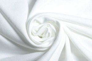Detailed close-up of soft white knitted fabric texture with elegant draped spiral pattern