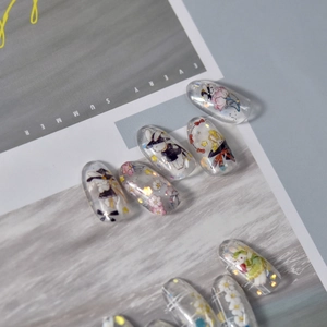 Detail of transparent press-on nails featuring cute hand-painted bunnies and floral patterns