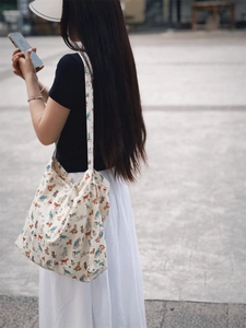 Detail view of large canvas tote bag with colorful cartoon dog prints and ivory fabric
