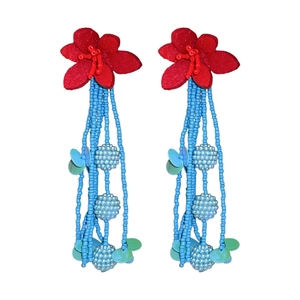 Vacation style earrings with red felt flowers and long blue beaded tassels on white background