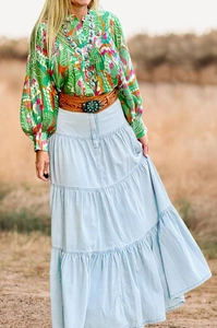Dettaglio gonna lunga in denim azzurro a balze con cintura in stile bohémien