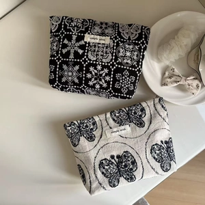 Close-up of embroidered cotton-linen cosmetic bags with flower and butterfly patterns