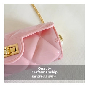 Close-up of pink quilted jelly bag featuring a gold turn-lock and fine metal chain strap